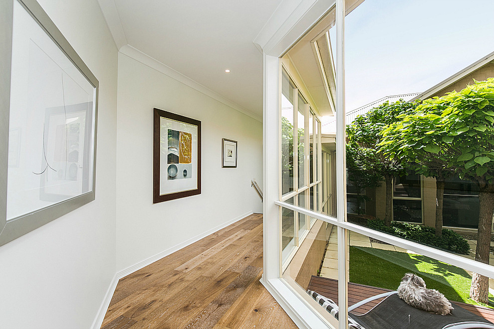 Großer Moderner Flur mit weißer Wandfarbe und braunem Holzboden in Geelong