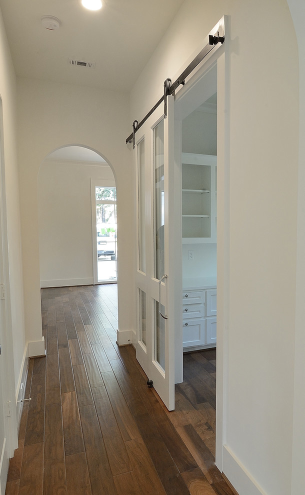 Esempio di un grande ingresso o corridoio classico con pareti bianche, pavimento in legno massello medio e pavimento marrone