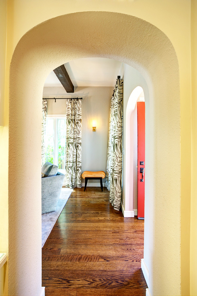 Modelo de recibidores y pasillos tradicionales renovados de tamaño medio con paredes beige y suelo de madera en tonos medios