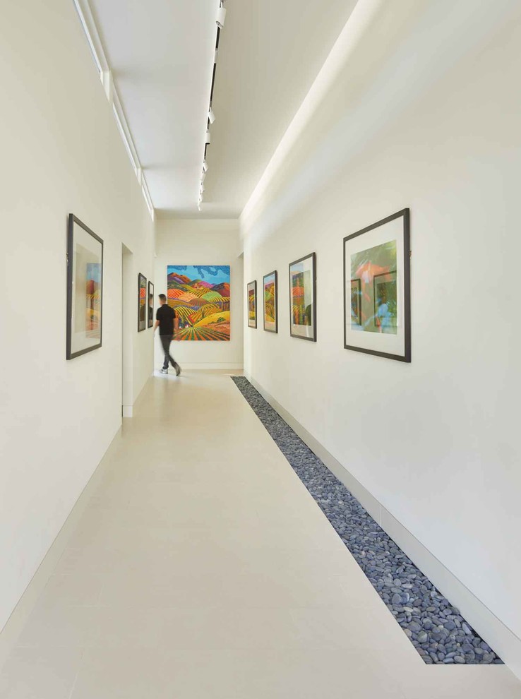 Hallway - modern limestone floor and white floor hallway idea in Dallas with white walls