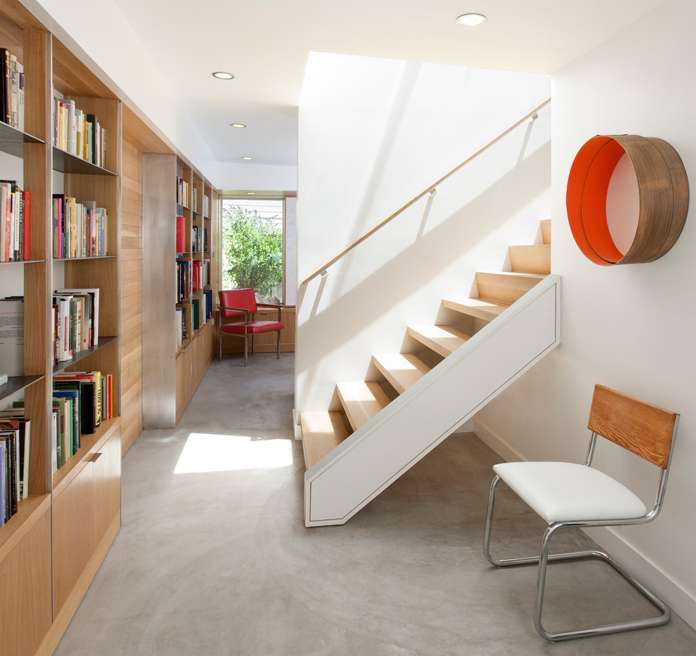 Ejemplo de recibidores y pasillos minimalistas con paredes blancas y suelo de cemento