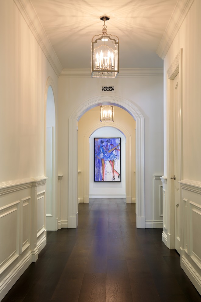 Example of a mid-sized classic dark wood floor and brown floor hallway design in Los Angeles with white walls