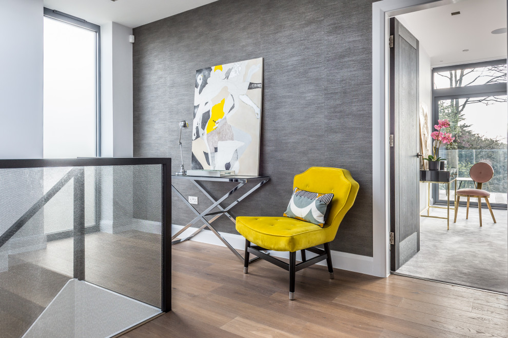 Idée de décoration pour un couloir design de taille moyenne avec un mur gris, un sol en bois brun et un sol beige.