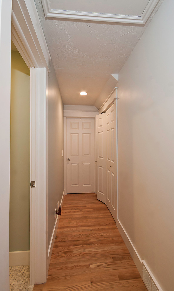 Immagine di un ingresso o corridoio minimal di medie dimensioni con pareti grigie e pavimento in legno massello medio