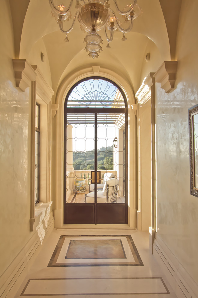 Réalisation d'un grand couloir tradition avec un mur beige et un sol en marbre.