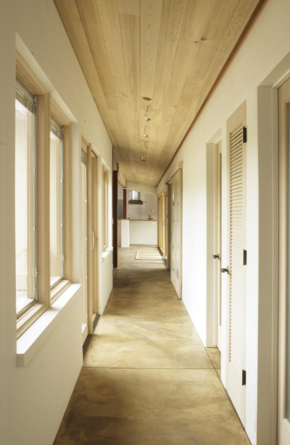 Hallway - mid-sized contemporary concrete floor hallway idea in Santa Barbara with white walls
