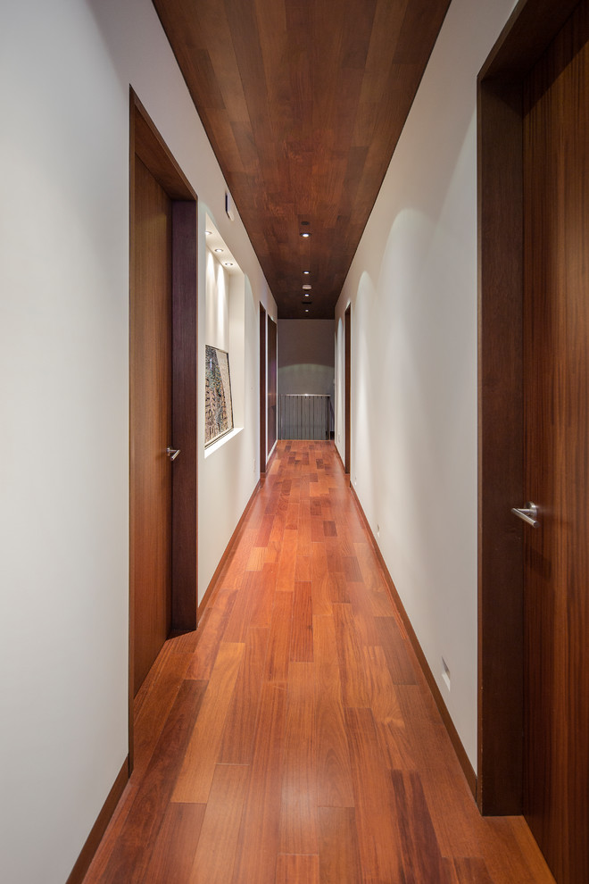 Ispirazione per un grande ingresso o corridoio minimal con pareti bianche e pavimento in legno massello medio