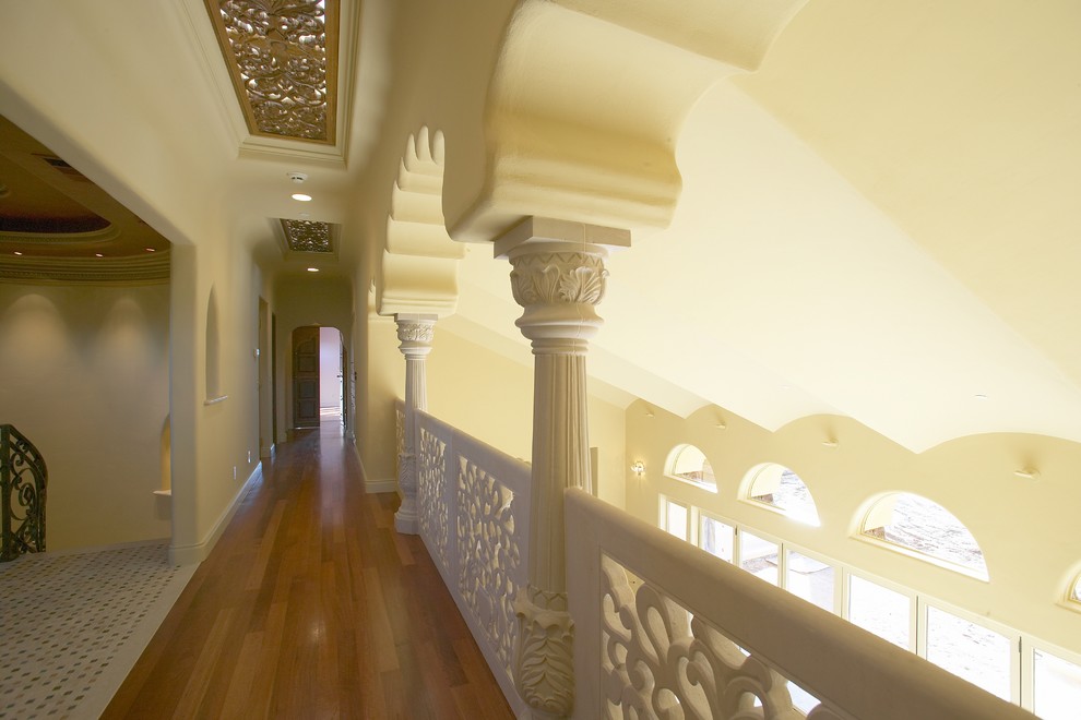 Exemple d'un couloir éclectique avec un mur blanc et un sol en bois brun.
