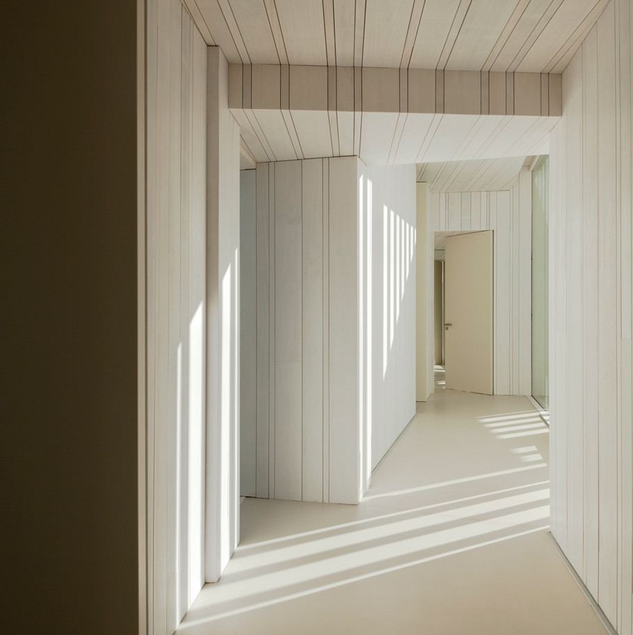 На фото: большой коридор в современном стиле с белыми стенами, бетонным полом и белым полом с