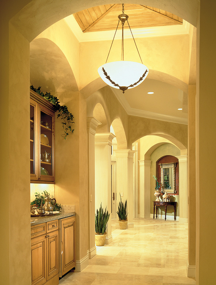Idée de décoration pour un grand couloir méditerranéen avec un mur beige et un sol en travertin.