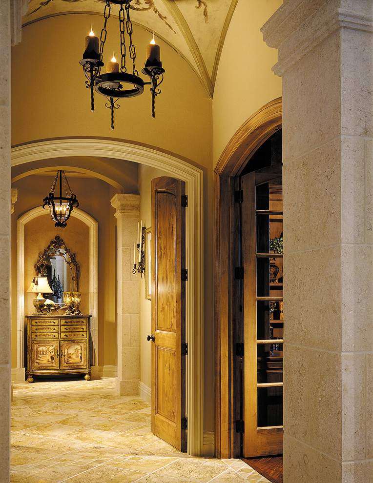 Example of a large tuscan travertine floor hallway design in Miami with beige walls