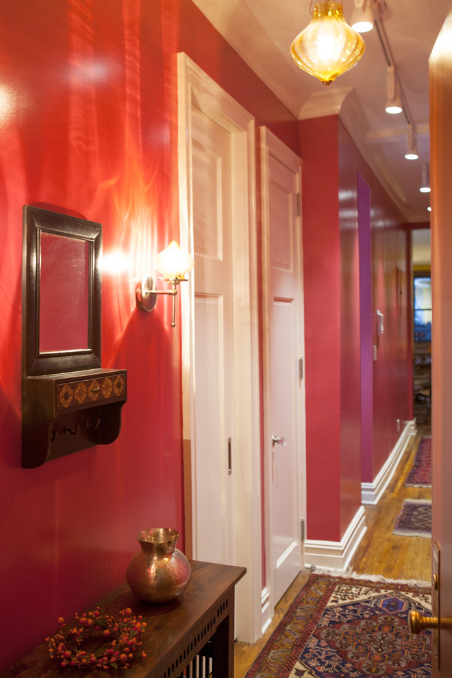 ニューヨークにあるお手頃価格の小さなエクレクティックスタイルのおしゃれな廊下 (赤い壁、濃色無垢フローリング) の写真