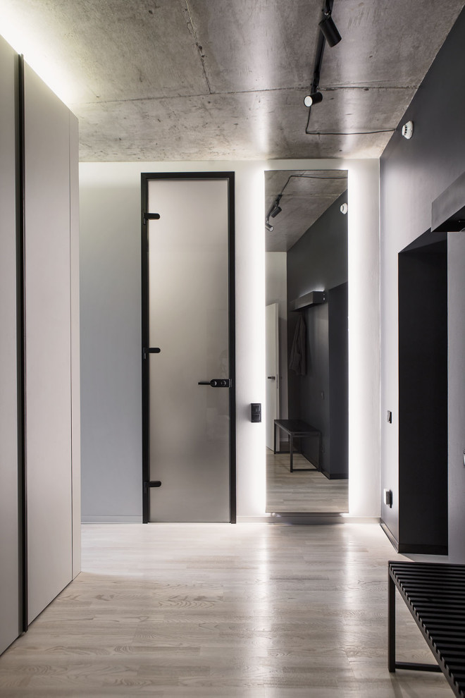 Bild på en minimalistisk hall, med grå väggar