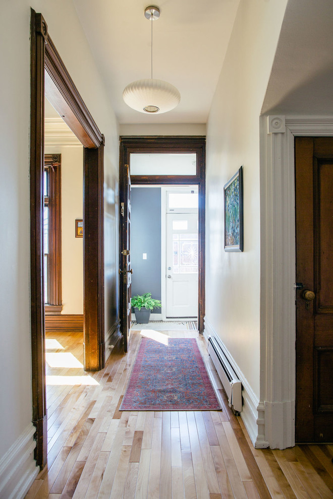 Immagine di un piccolo ingresso o corridoio chic con pareti bianche e parquet chiaro