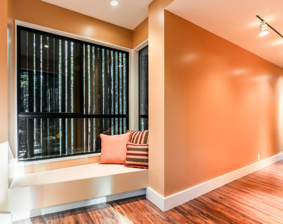 Large transitional medium tone wood floor and orange floor hallway photo in San Francisco with orange walls