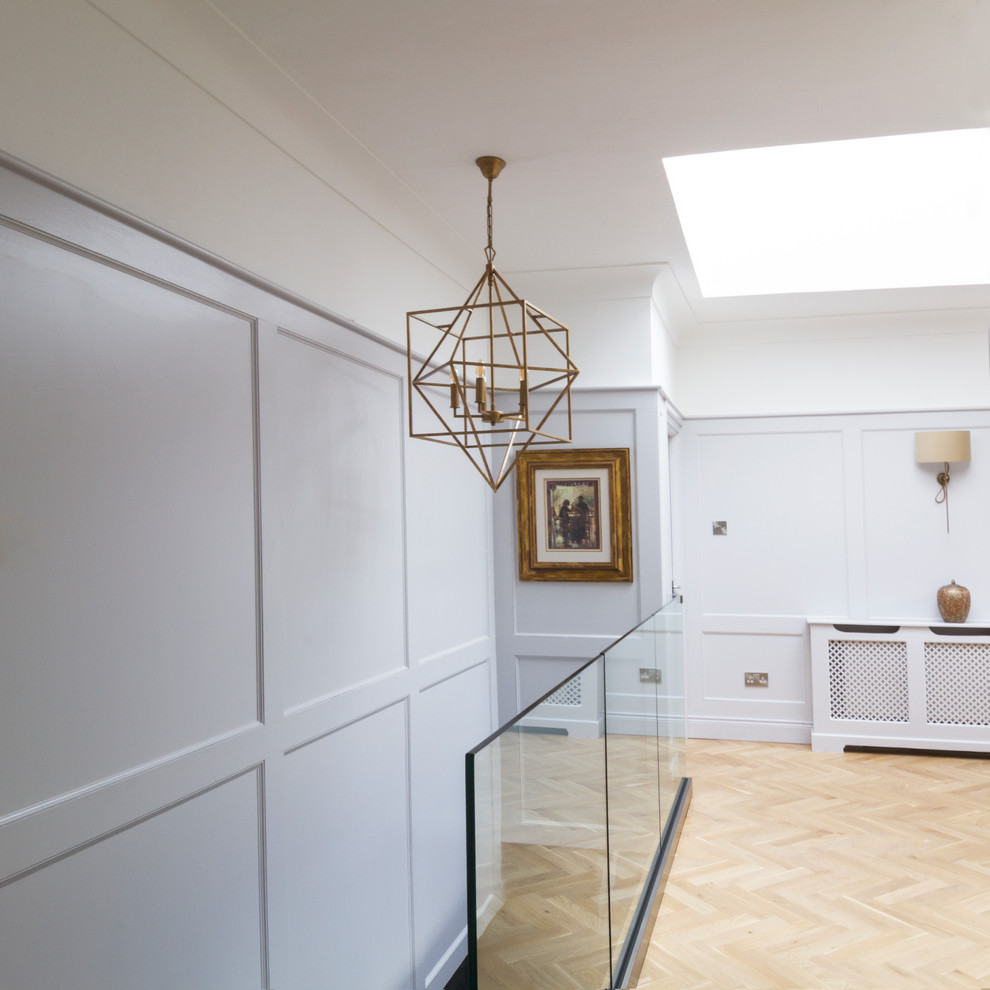 Cette image montre un couloir traditionnel de taille moyenne avec un mur gris, parquet clair et un sol beige.