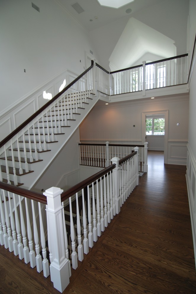 На фото: коридор в классическом стиле с белыми стенами, паркетным полом среднего тона и коричневым полом с