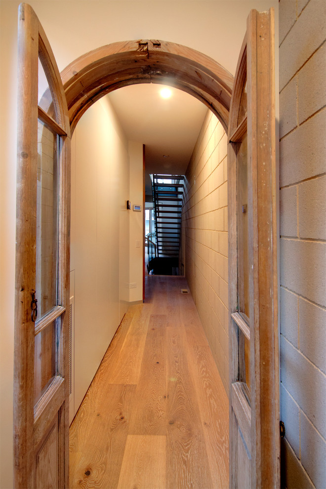 Foto de recibidores y pasillos eclécticos pequeños con paredes marrones, suelo de madera en tonos medios y suelo marrón