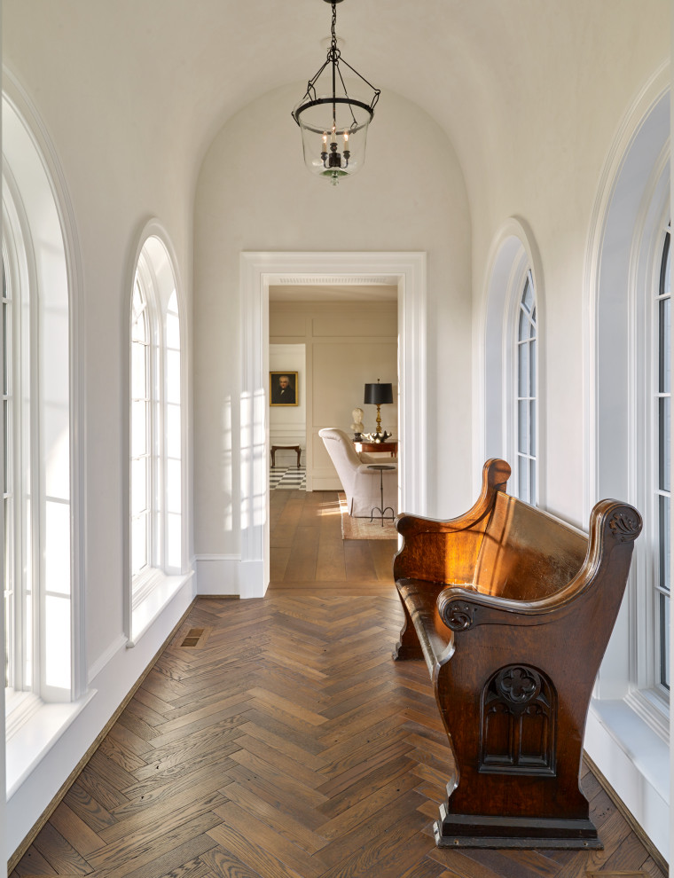 Свежая идея для дизайна: коридор среднего размера в классическом стиле с белыми стенами, паркетным полом среднего тона, коричневым полом и сводчатым потолком - отличное фото интерьера