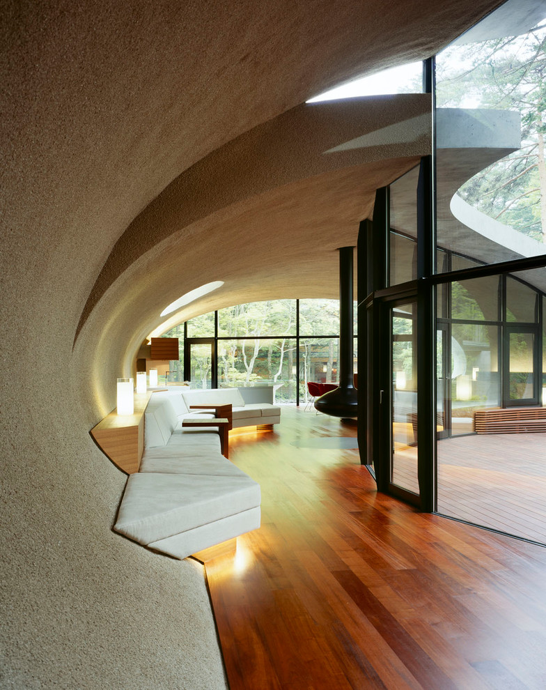 Idée de décoration pour un couloir design avec un mur marron, un sol en bois brun et un sol marron.
