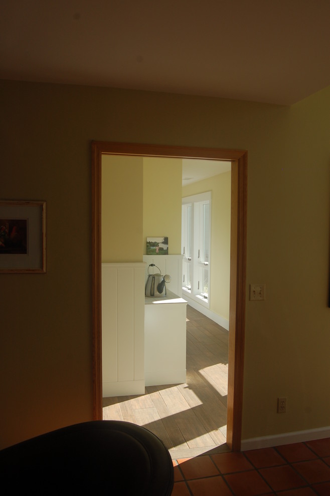 Immagine di un ingresso o corridoio minimal di medie dimensioni con pareti gialle e pavimento in legno massello medio