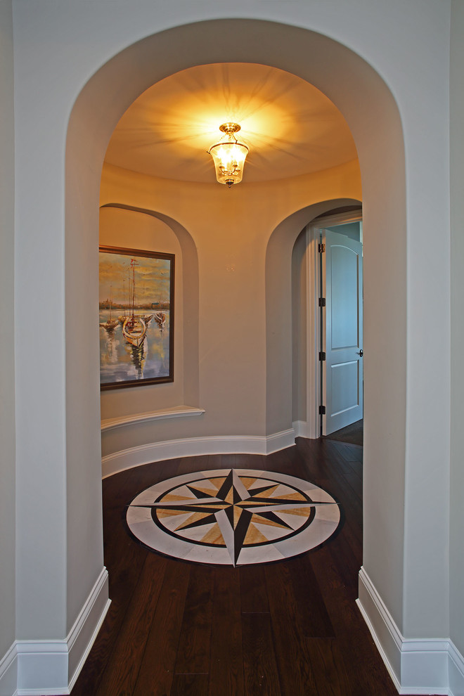 Идея дизайна: большой коридор в стиле неоклассика (современная классика) с бежевыми стенами, темным паркетным полом и коричневым полом