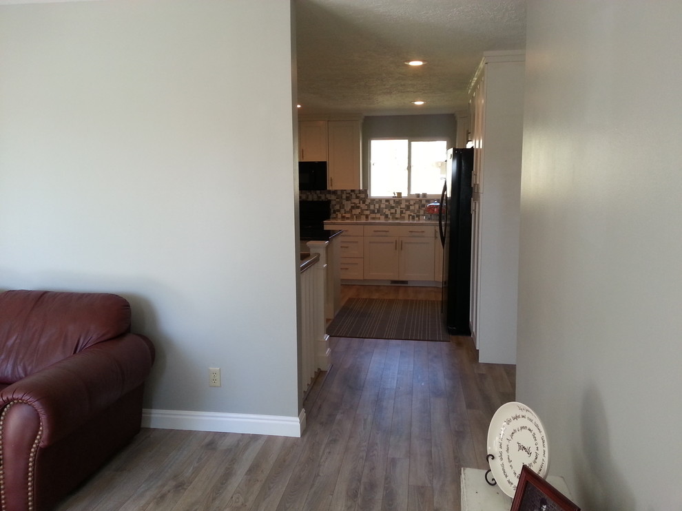 Aménagement d'un couloir de taille moyenne avec un mur gris et un sol en bois brun.