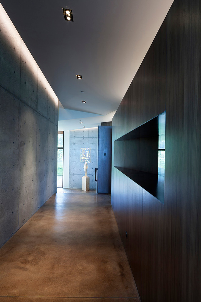 Hallway - large contemporary concrete floor and brown floor hallway idea in Other with white walls