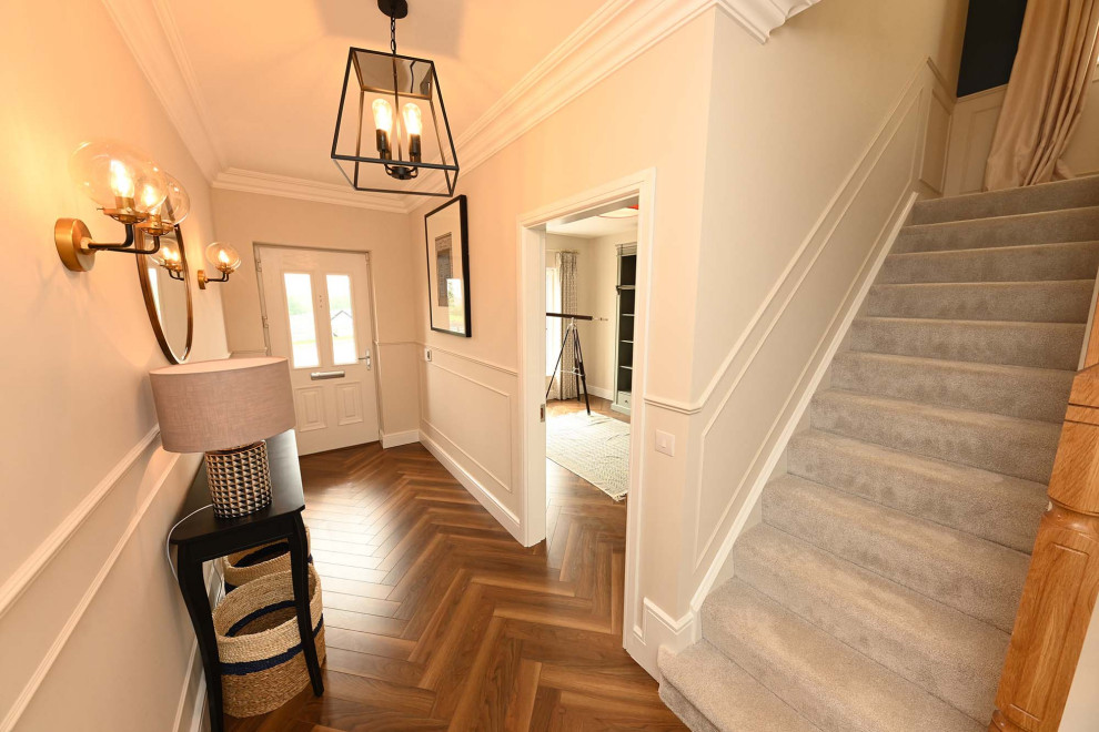 Esempio di un ingresso o corridoio bohémian con pareti bianche, pavimento in laminato e pavimento marrone