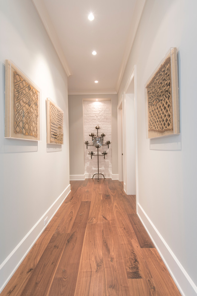 Large island style medium tone wood floor hallway photo in Tampa with blue walls