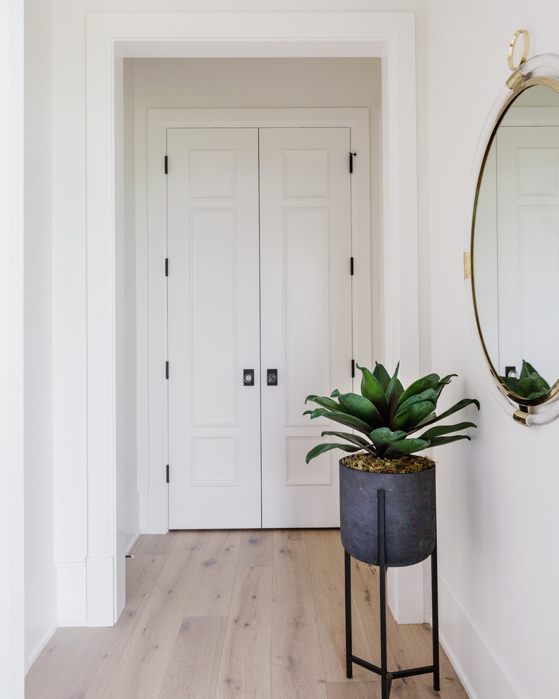 Inspiration for a huge light wood floor hallway remodel in Calgary with white walls