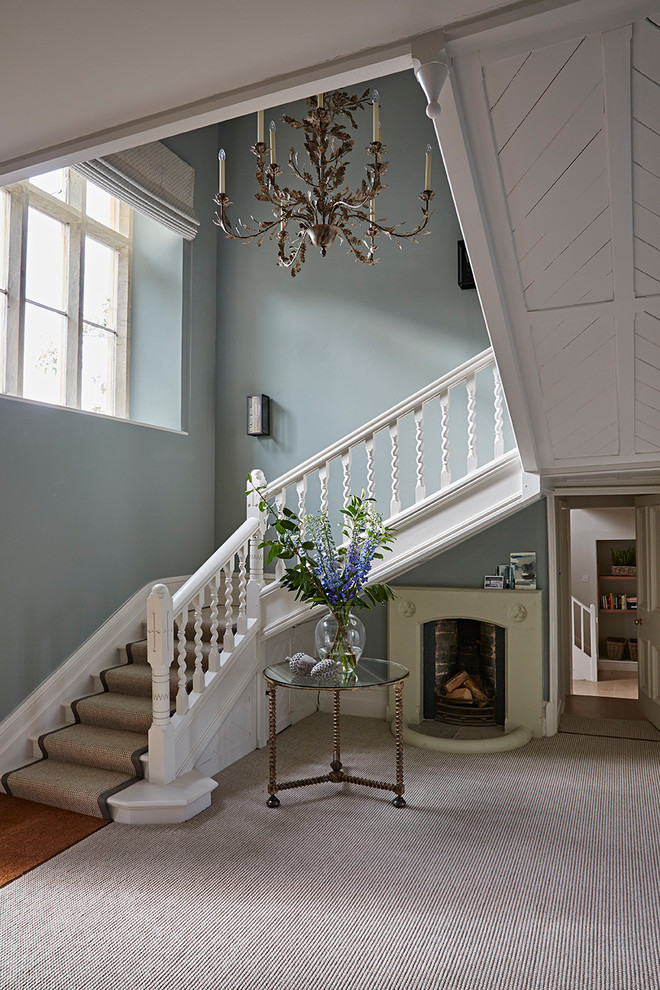 Cette image montre un grand couloir traditionnel avec un mur bleu, moquette et un sol gris.