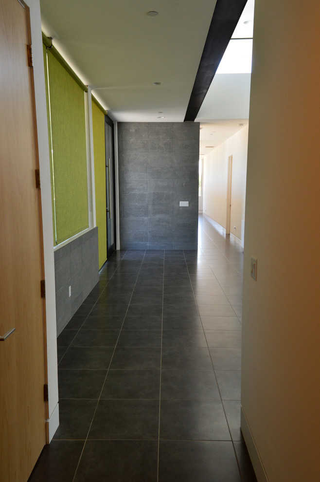 Cette image montre un couloir design de taille moyenne avec un mur gris.
