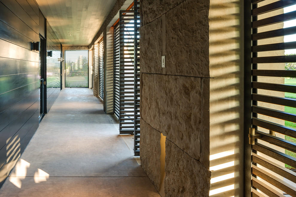 Modelo de recibidores y pasillos minimalistas de tamaño medio con paredes negras y suelo de cemento