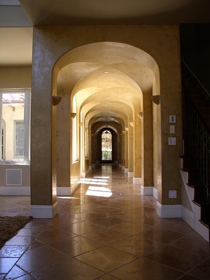 Ejemplo de recibidores y pasillos mediterráneos extra grandes con paredes beige y suelo de madera oscura