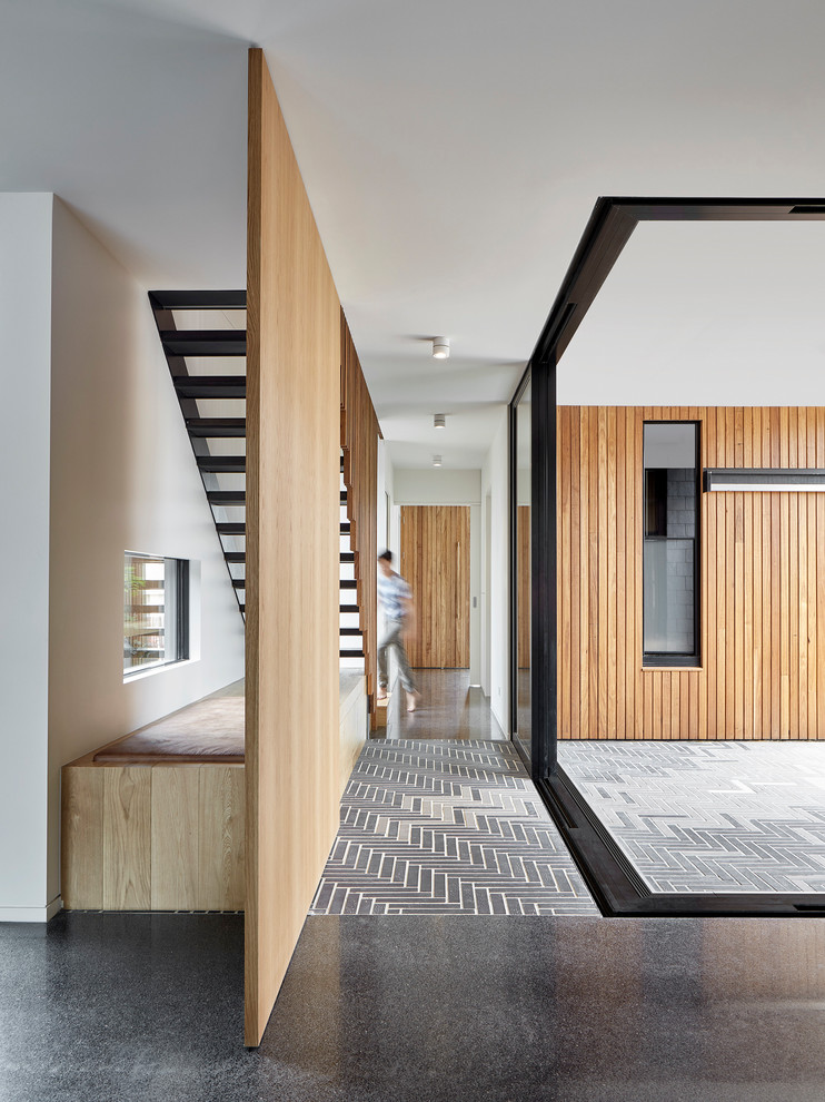 На фото: коридор в современном стиле с бетонным полом и черным полом с