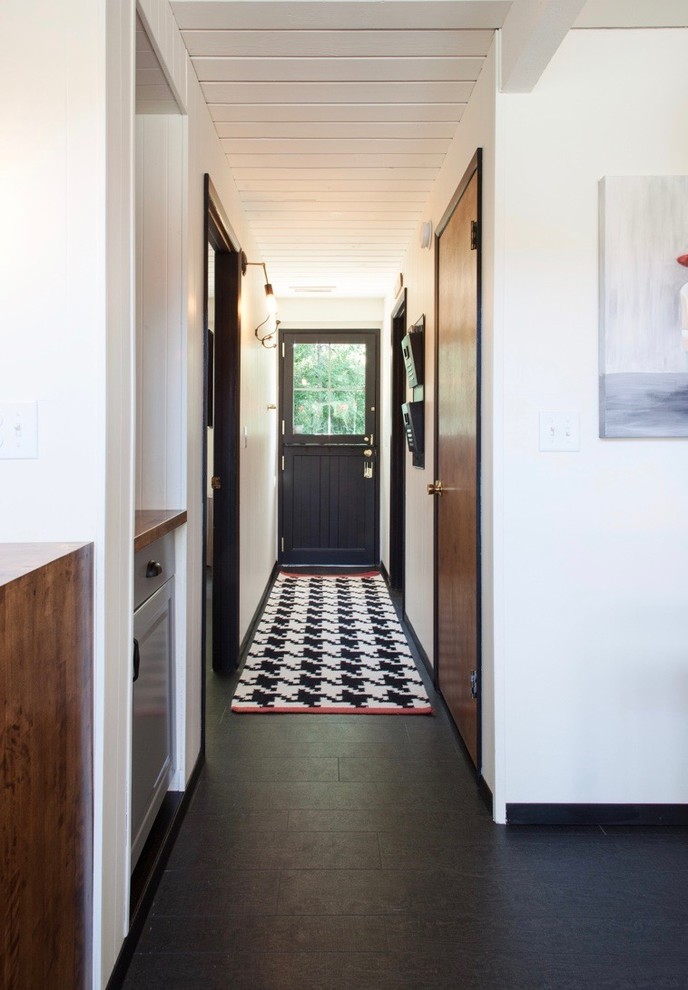 Пример оригинального дизайна: коридор среднего размера в стиле фьюжн с белыми стенами, черным полом и полом из ламината