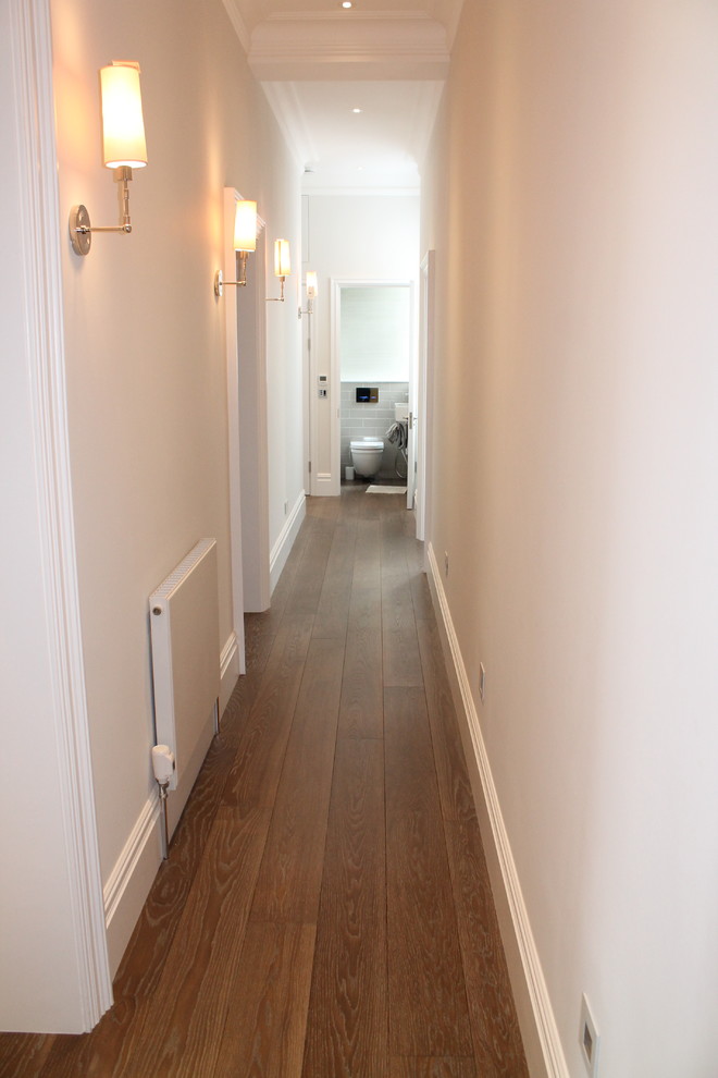 На фото: большой коридор в классическом стиле с серыми стенами и темным паркетным полом