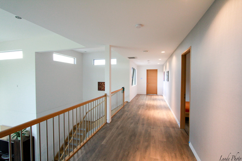 Hallway - mid-sized modern light wood floor hallway idea in Vancouver with white walls