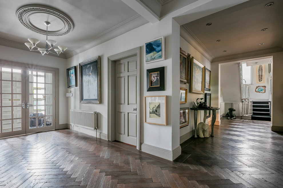 Geräumiger Klassischer Flur mit weißer Wandfarbe, dunklem Holzboden und braunem Boden in Dublin