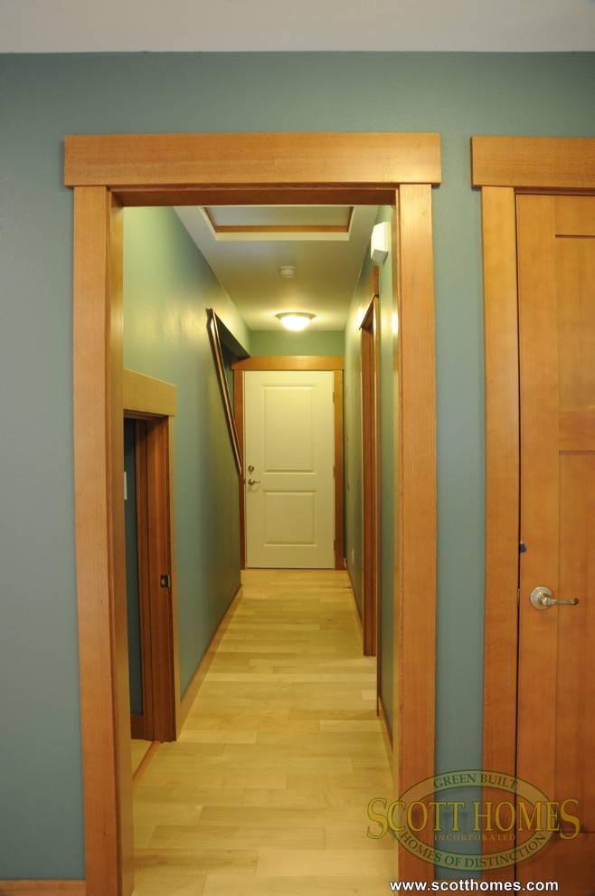 Ejemplo de recibidores y pasillos de estilo americano de tamaño medio con paredes verdes y suelo de madera clara