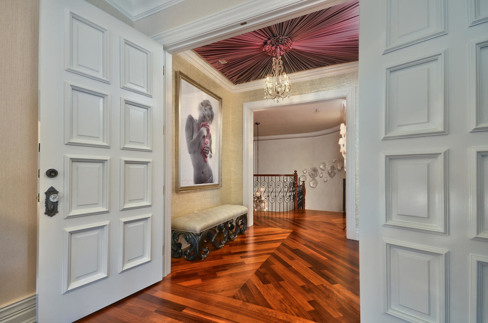 Immagine di un grande ingresso o corridoio classico con pareti beige e pavimento in legno massello medio