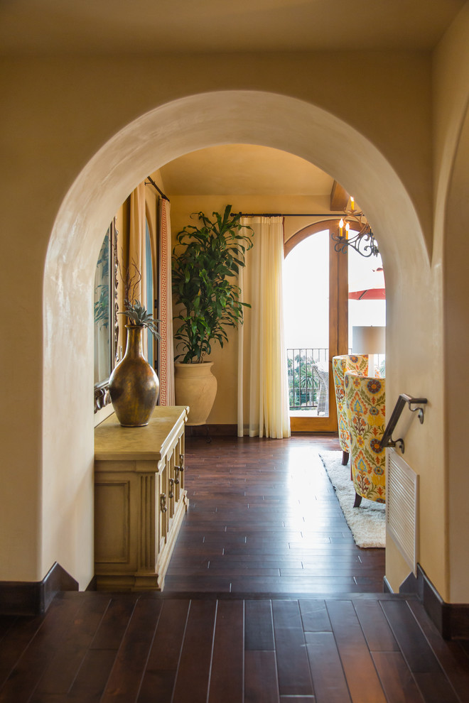 Ispirazione per un ingresso o corridoio mediterraneo di medie dimensioni con pareti beige, parquet scuro e pavimento marrone
