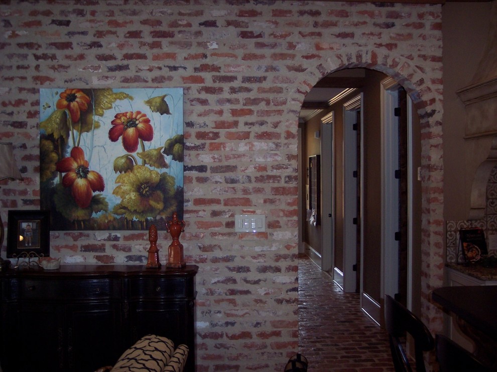 ニューオリンズにある高級な中くらいなトラディショナルスタイルのおしゃれな廊下 (赤い壁、レンガの床) の写真
