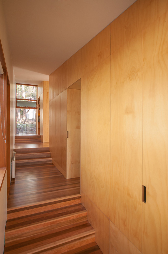 Cette image montre un couloir design avec un sol en bois brun.