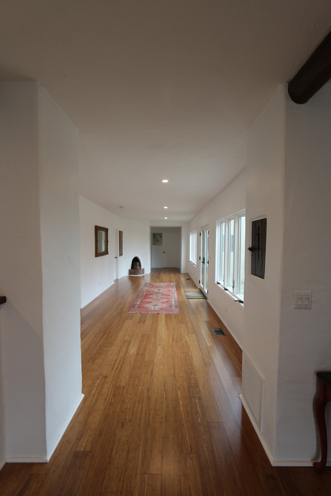 Пример оригинального дизайна: большой коридор в стиле рустика с полом из бамбука и белыми стенами