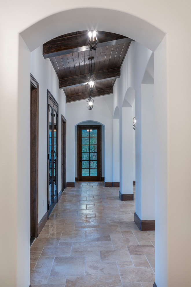 Idéer för att renovera en mellanstor medelhavsstil hall, med vita väggar, travertin golv och beiget golv