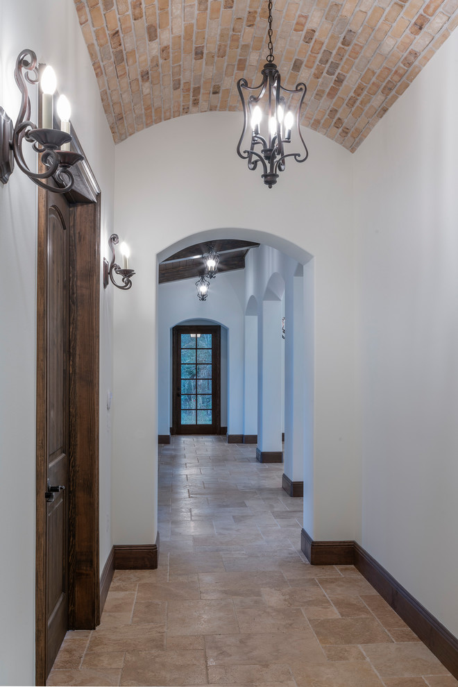 Пример оригинального дизайна: коридор среднего размера в средиземноморском стиле с белыми стенами, полом из травертина и бежевым полом