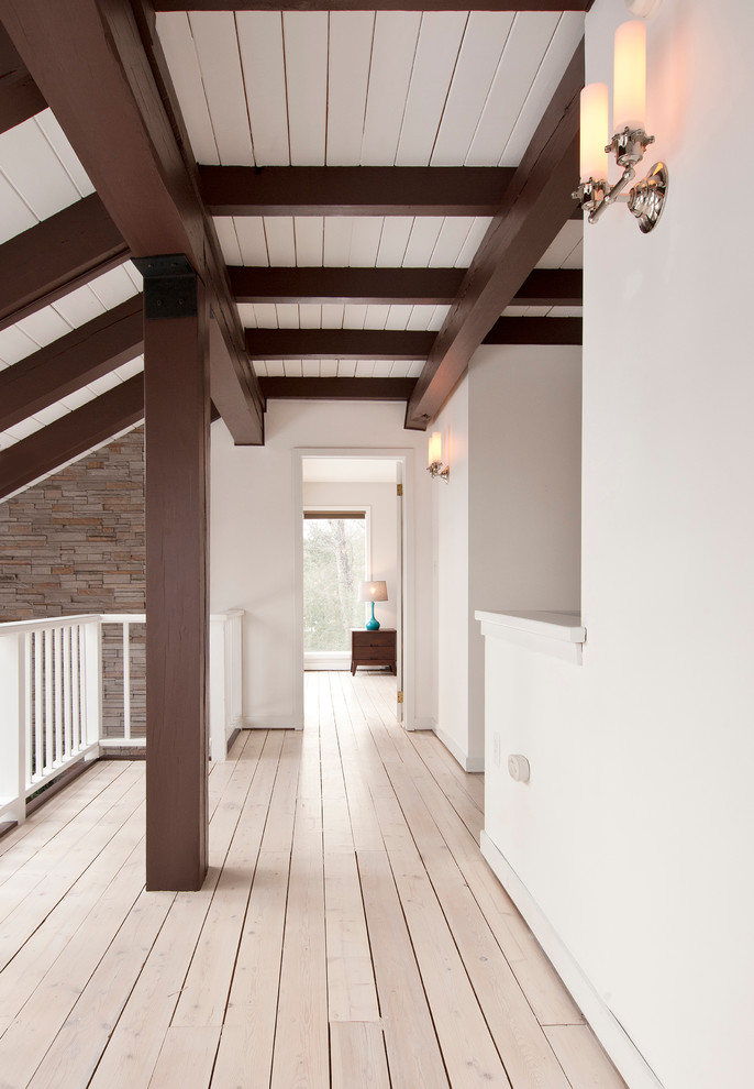 Ejemplo de recibidores y pasillos rústicos de tamaño medio con paredes blancas y suelo de madera clara