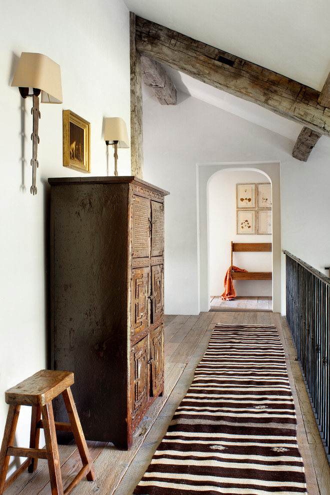 Immagine di un ingresso o corridoio stile rurale con pareti bianche e pavimento in legno massello medio